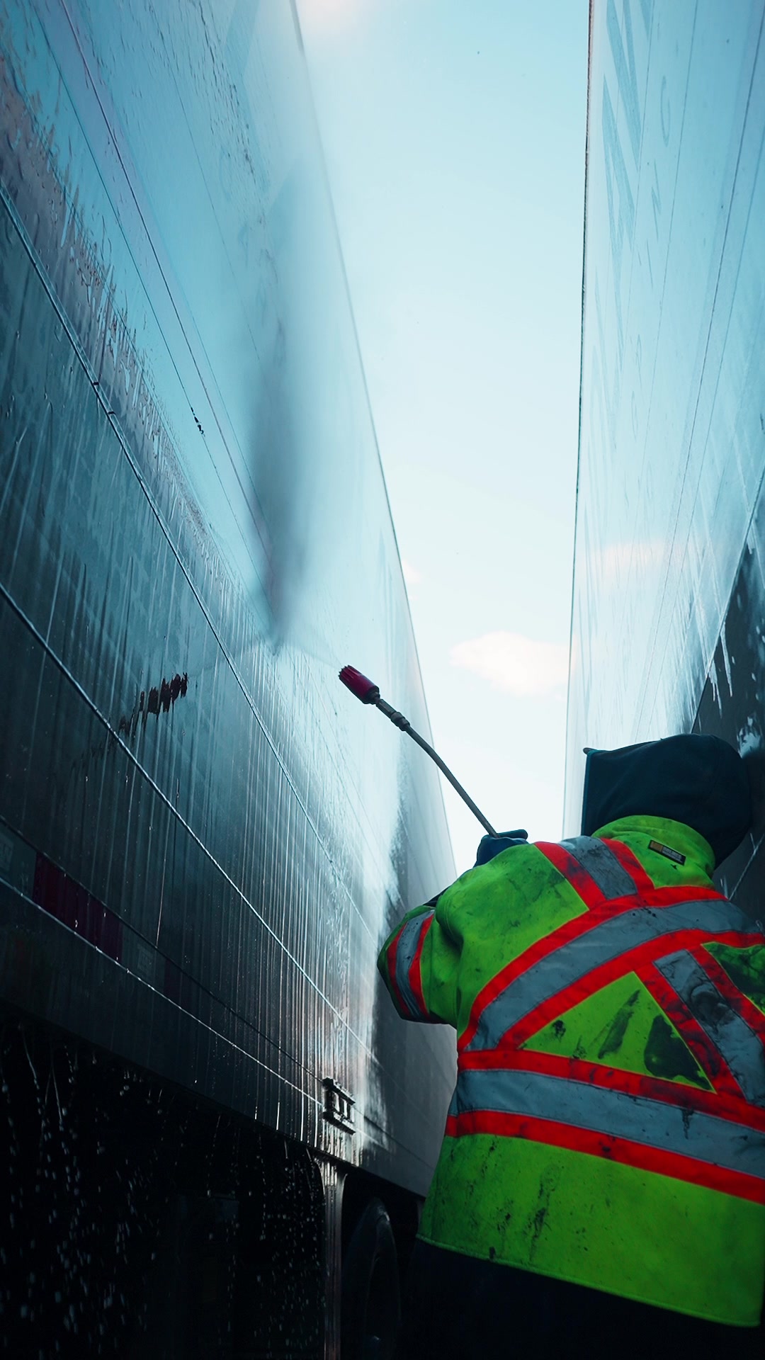 Équipe L'Escouade lavant une flotte de camions dans la vapeur